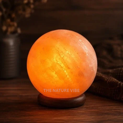 Handcrafted ball shaped Himalayan pink salt lamp H 17.50cm W 14.50cm glowing on neem base by The Nature Vibe